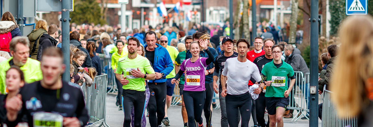 Tientallen hardlopers rennen tijdens de 20 van Alphen door de van Boetzelaerstraat in Alphen aan den Rijn. Bron: Orange Pictures