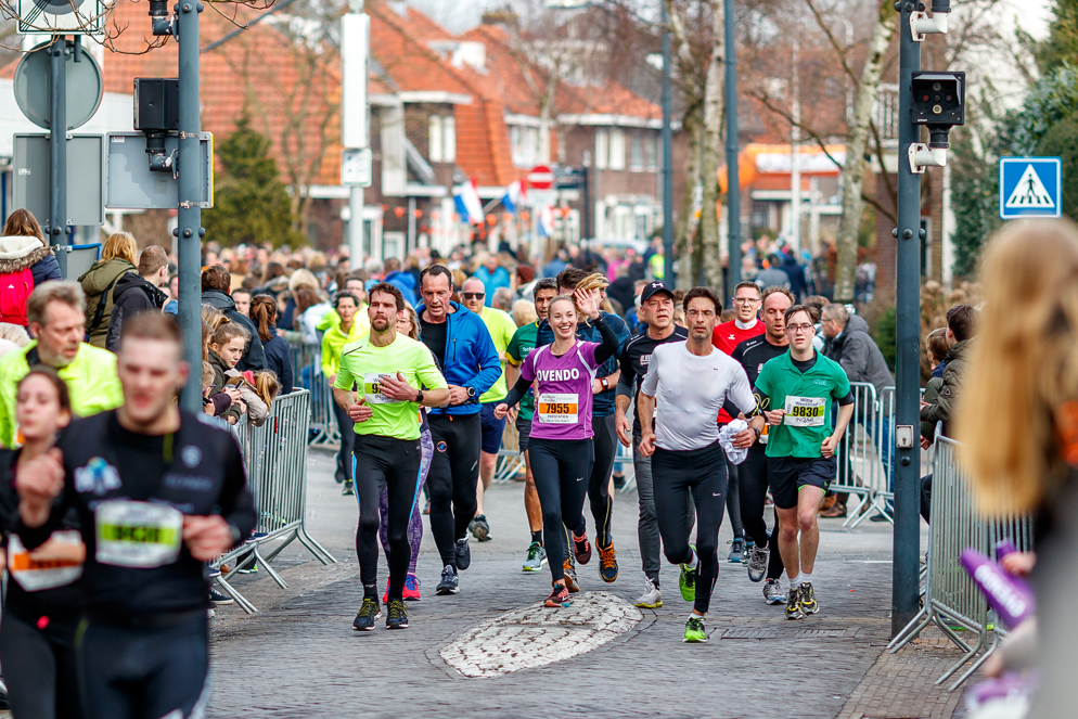 Tientallen hardlopers rennen tijdens de 20 van Alphen door de van Boetzelaerstraat in Alphen aan den Rijn.