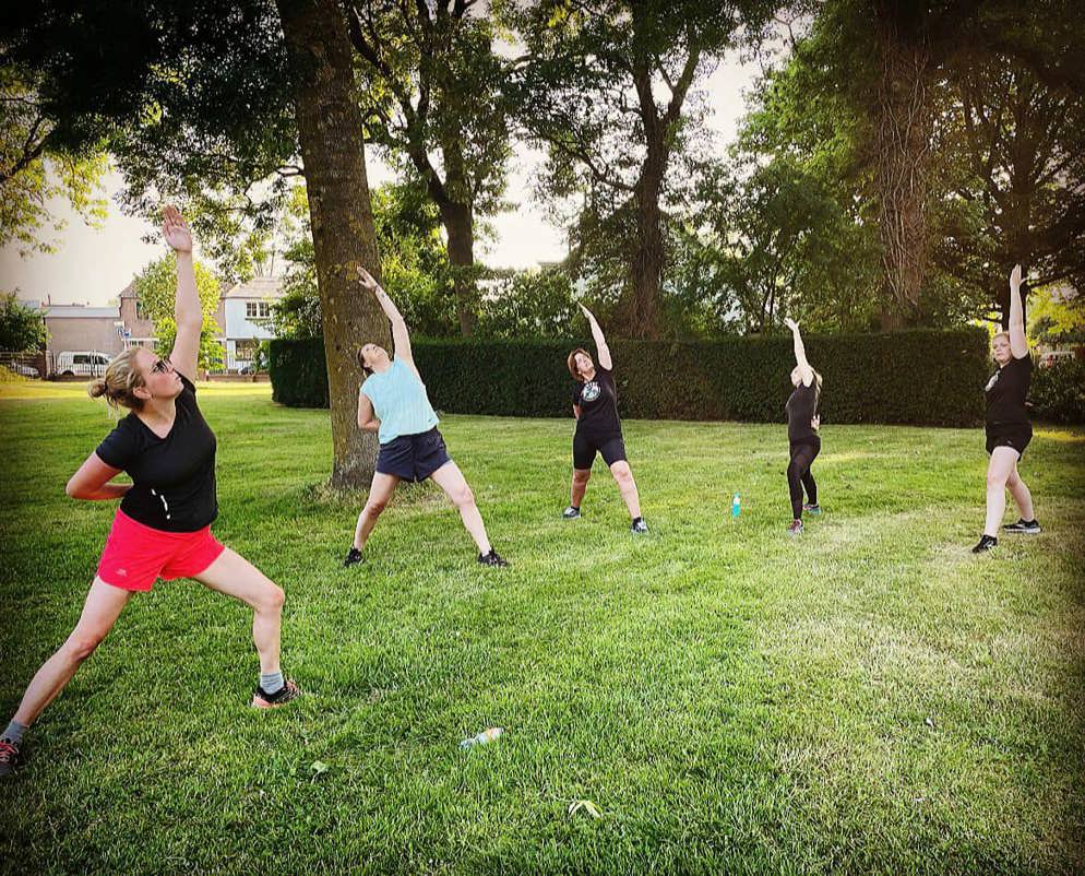 Dames doen een stretch tijdens de cooling down van de SlowRun les.