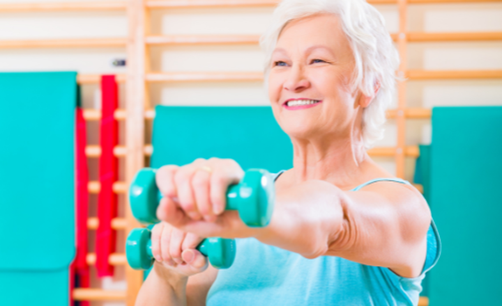 Senioren mevrouw in actie met dumbells