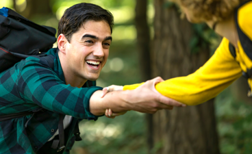 Een jongen pakt tijdens het hiken een uitgestoken hand van een ander.
