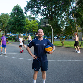 Buurtsportcoach Jochem poseert op het basketbalveld tijdens het 3X3 basketballen