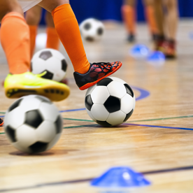 Een close-up van voeten van zaalvoetballende kinderen