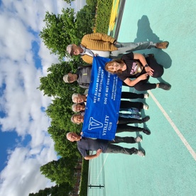 De sporters van de Vitality Club in het Europapark poseren met een reclame banner op het sportveld.