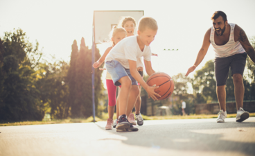 Een gezin is buiten aan het basketballen