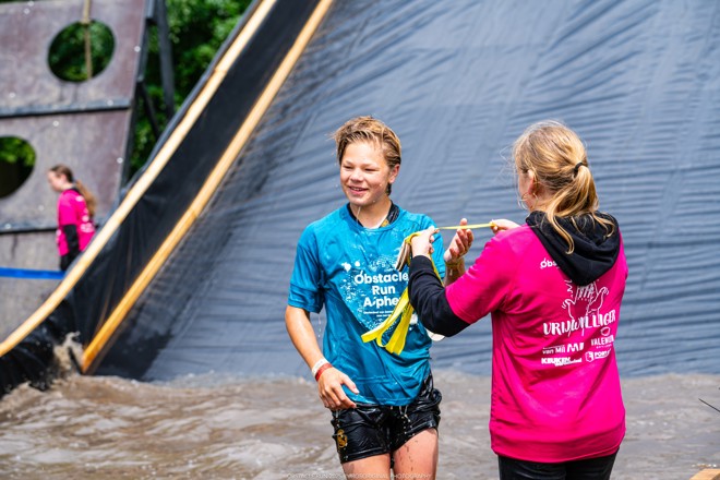 Vrijwilliger doet medaille om bij deelnemer tijdens Obstacle Run Alphen (fotocredit Rosoriginal)