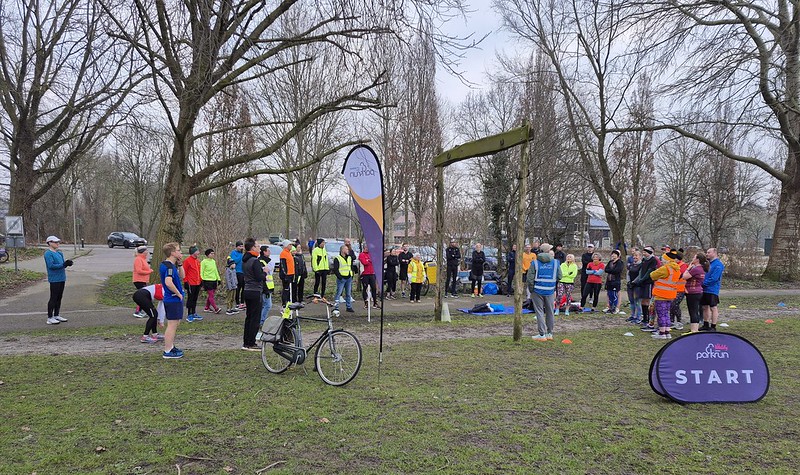 Een groep van zo'n 20 deelnemers verzameld zich bij het startpunt van de Zegerplas Parkrun