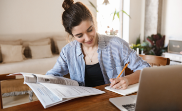 Een meisje is aan  het studeren achter de laptop.