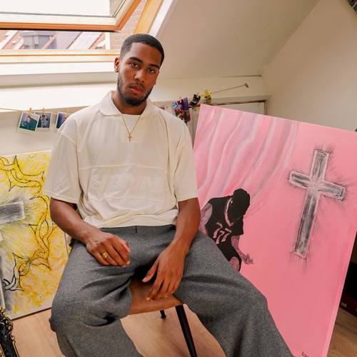 Isodor Slewe poseert tussen de schilderijen