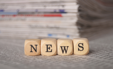 Dobbelstenen met elk een letter, Het vormt het woord: news