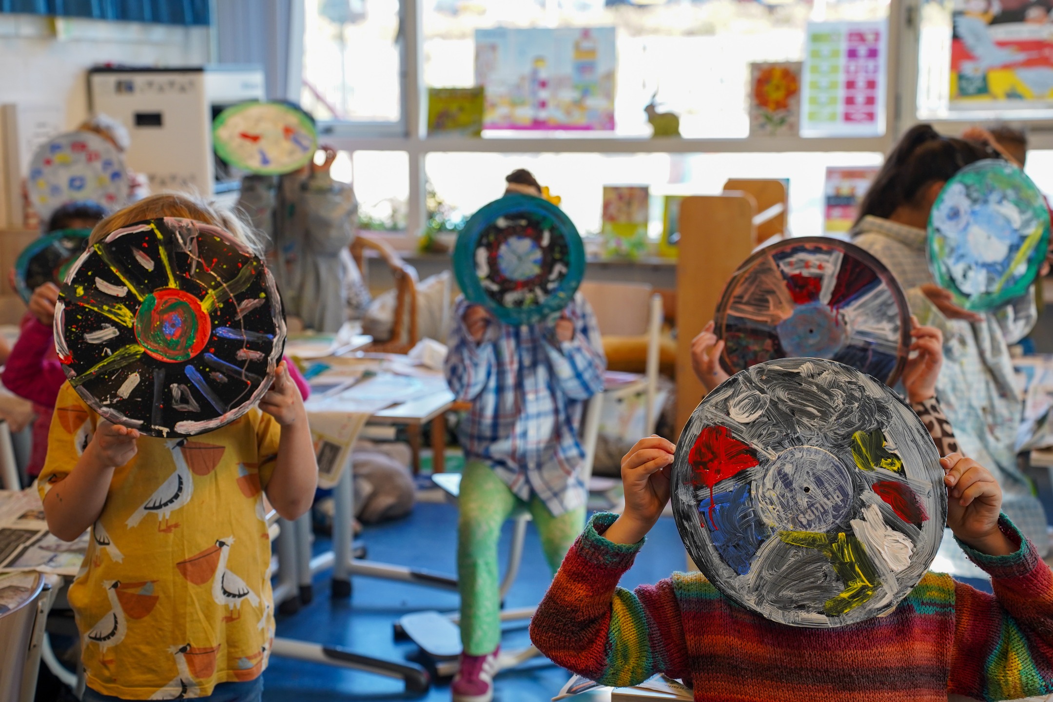 Kinderen van het basisonderwijs laten hun versierde LP's zien.