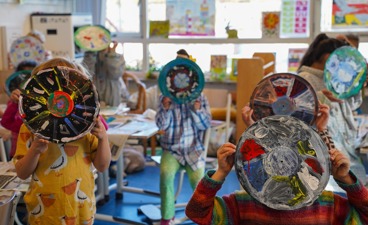 Kinderen van het basisonderwijs laten hun versierde LP's zien.
