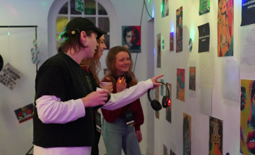 Een vrijwilliger geeft een rondleiding bij een evenement met kunst