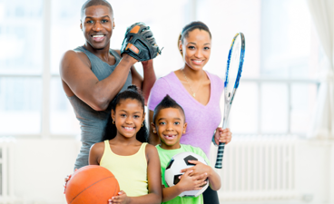 Sportief gezin poseert met verschillende sportmaterialen.