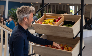 Raymond Pet pakt een appel uit de fruitkisten in het Scala College.