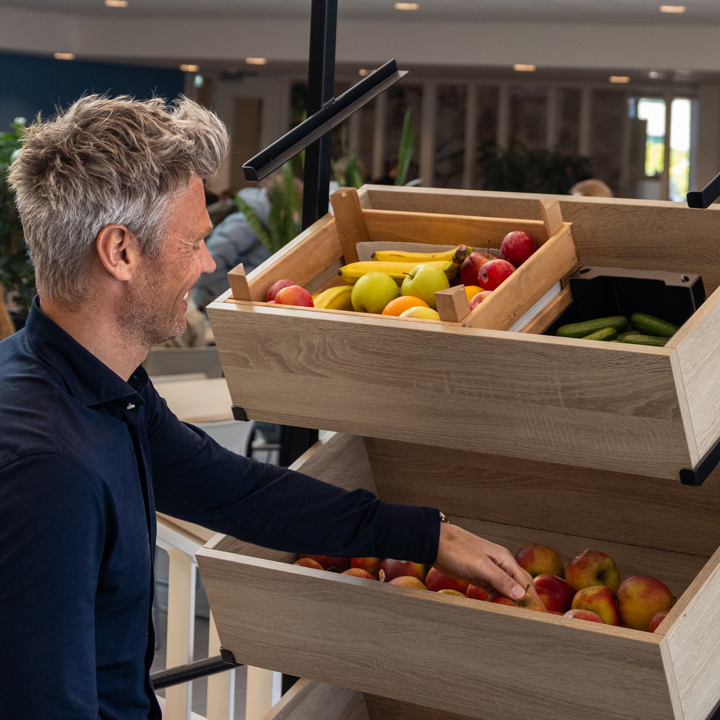 Raymond Pet pakt een appel uit de fruitkisten in het Scala College.