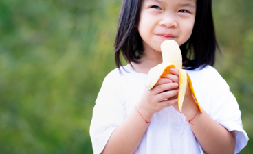 Jong meisje eet een banaan