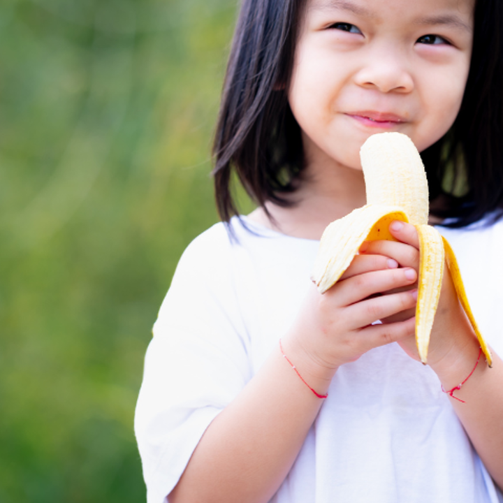 Jong meisje eet een banaan