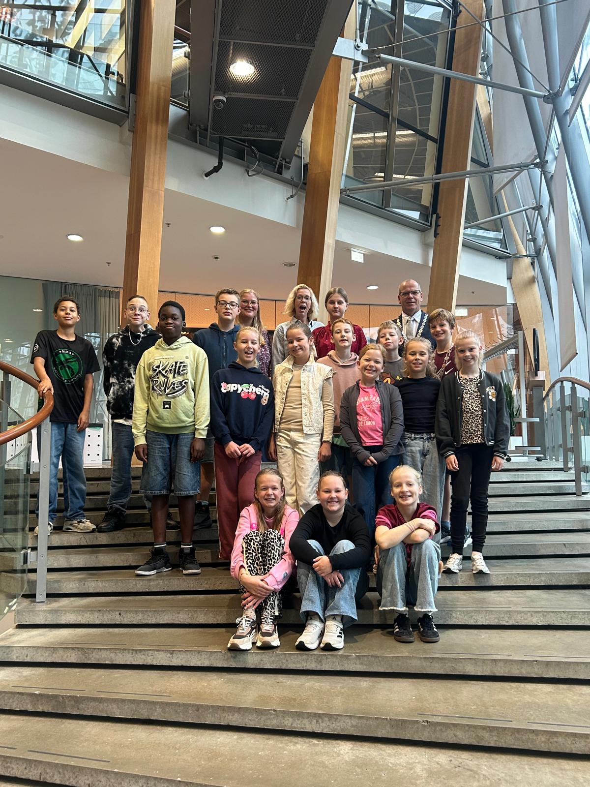 kinderburgemeester Sebastiaan en zijn klasgenoten van de basisschool De Fontein poseren met Loco burgemeester Schotanus