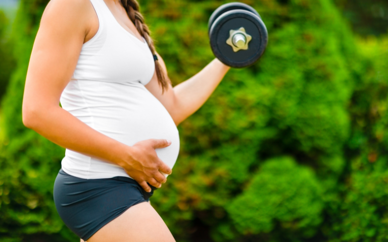 vrouw met zwangere buik en dumbell