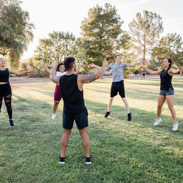 Groep volwassenen is buiten aan het trainen