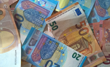 Een foto van verschillende bankbiljetten over elkaar.