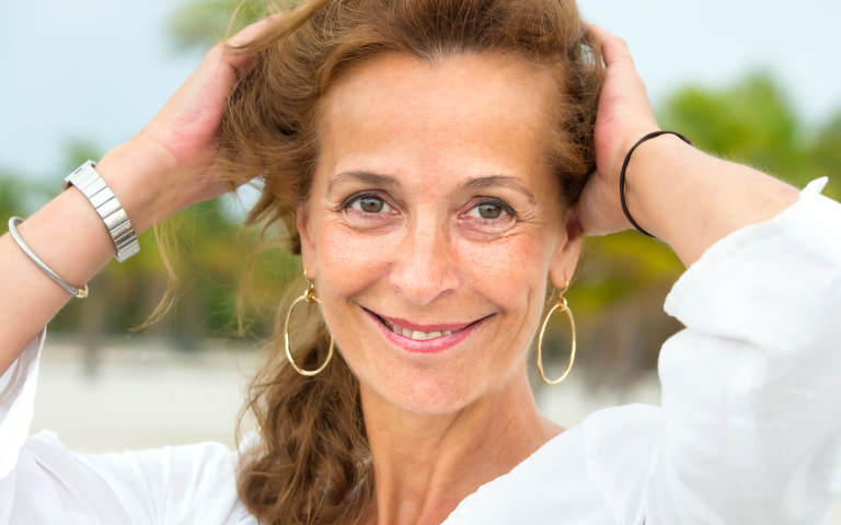 Energieke vrouw foto van lachend gezicht en handen in het haar. 